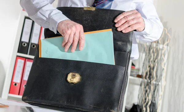 Businessman pulling out folders from his briefcase — Stock Photo, Image