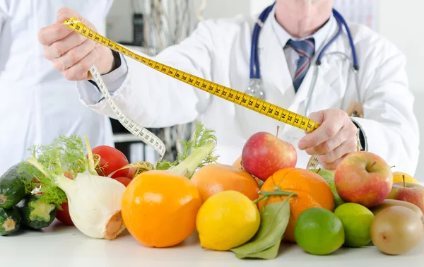Médico nutricionista sosteniendo una cinta métrica —  Fotos de Stock