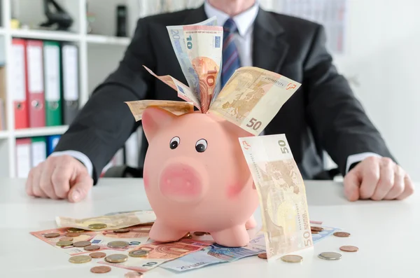Businessman sitting in front of his savings — Stock Photo, Image