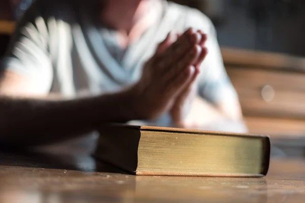 Mann betet Hände auf einer Bibel — Stockfoto