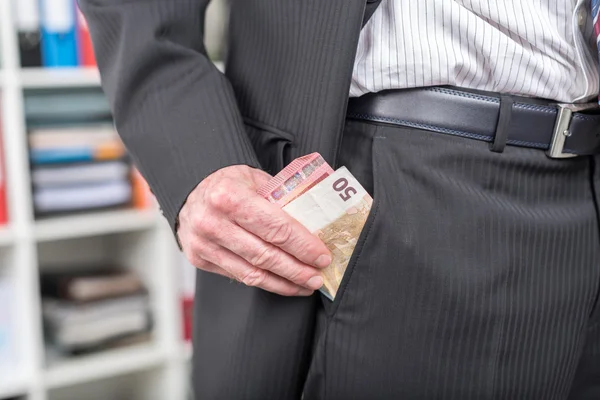 Businessman removing banknotes from his pocket — Stock Photo, Image