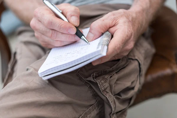 Homme prenant des notes sur un livre de poche — Photo