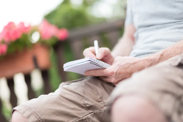 Uomo che prende appunti su un libro tascabile — Foto Stock