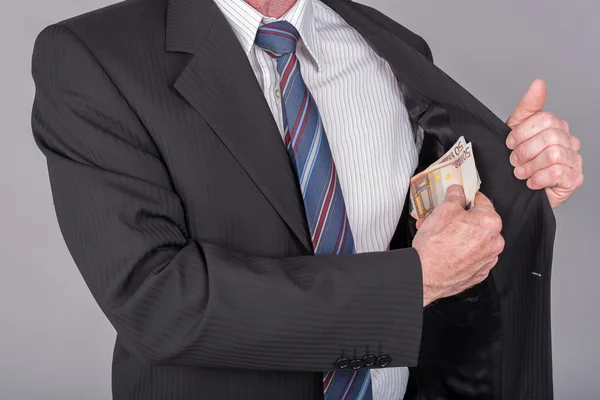 Empresario sacando billetes de su bolsillo — Foto de Stock
