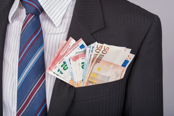 Uomo d'affari con un sacco di soldi in tasca — Foto Stock