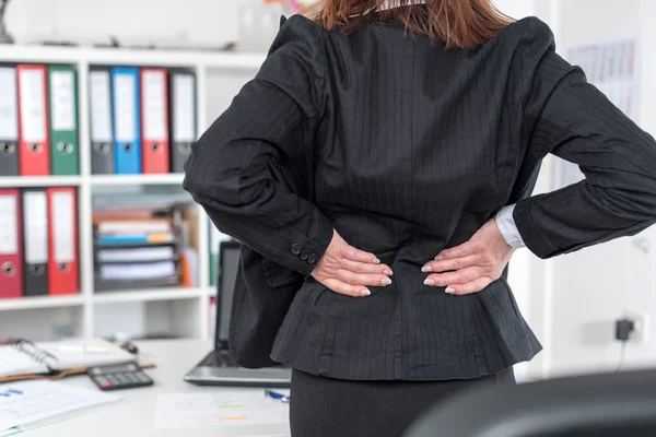 Mujer de negocios que sufre de dolor de espalda — Foto de Stock