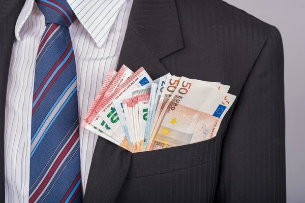 Businessman with a lot of money in his pocket Royalty Free Stock Photos