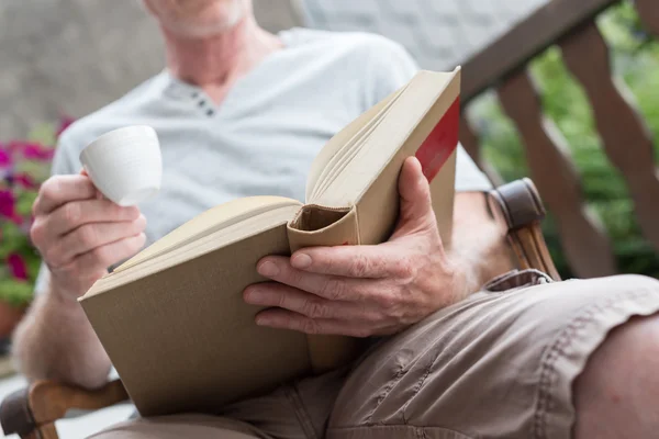 Uomo che legge un libro all'aperto — Foto Stock