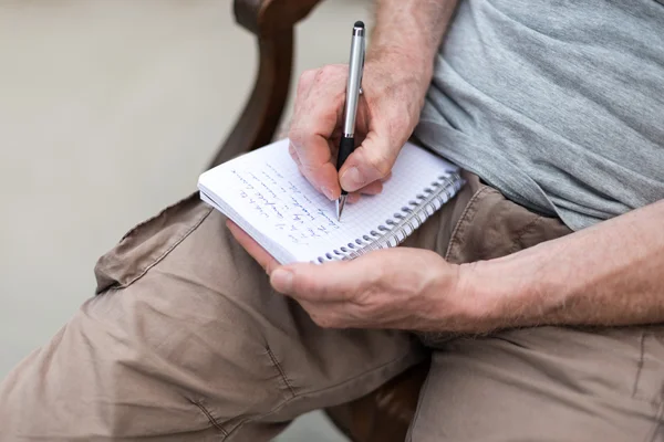 Uomo che prende appunti su un libro tascabile — Foto Stock