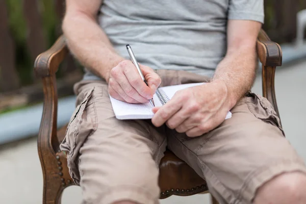 Άτομο που παίρνει σημειώσεις πάνω σε ένα βιβλίο τσέπης — Φωτογραφία Αρχείου