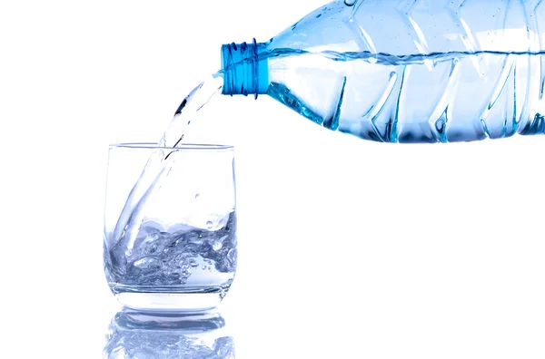 Water poured from a plastic bottle into a glass — Stock Photo, Image