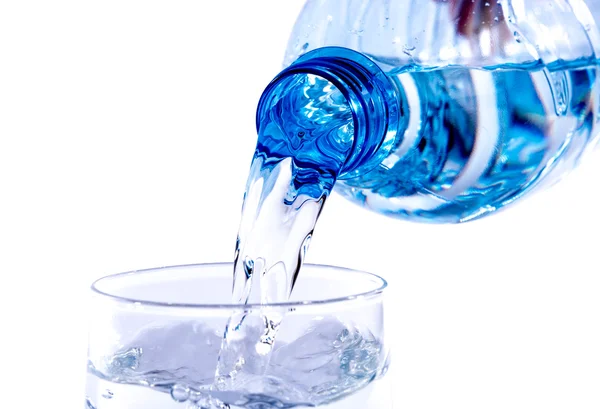 Water poured from a plastic bottle into a glass — Stock Photo, Image