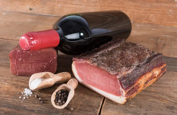 Carni affumicate con una bottiglia di vino — Foto Stock