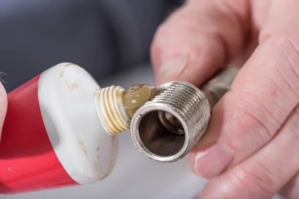 Plumber putting sealing paste on a thread — Stock Photo, Image