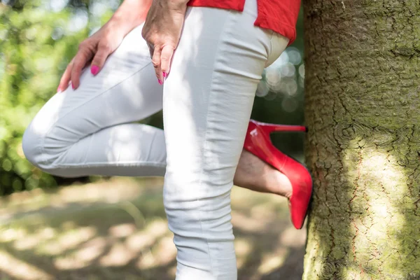 Vrouw leunend tegen een boom — Stockfoto