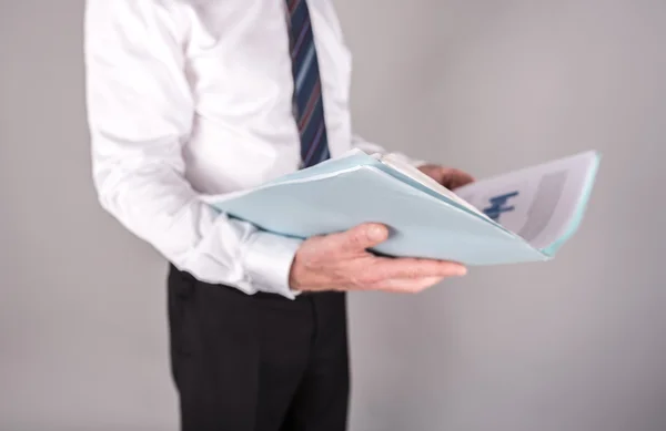 Geschäftsmann steht und liest einen Bericht — Stockfoto