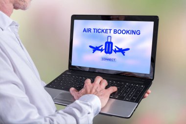 Ekranda uçak bileti konsepti olan bir dizüstü bilgisayar kullanan bir adam.