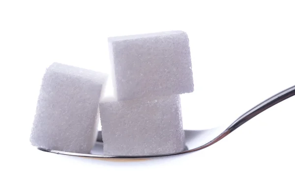Cubos de azúcar blanco en una cuchara — Foto de Stock