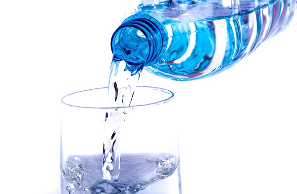 Воду наливають з пластикової пляшки в склянку — стокове фото
