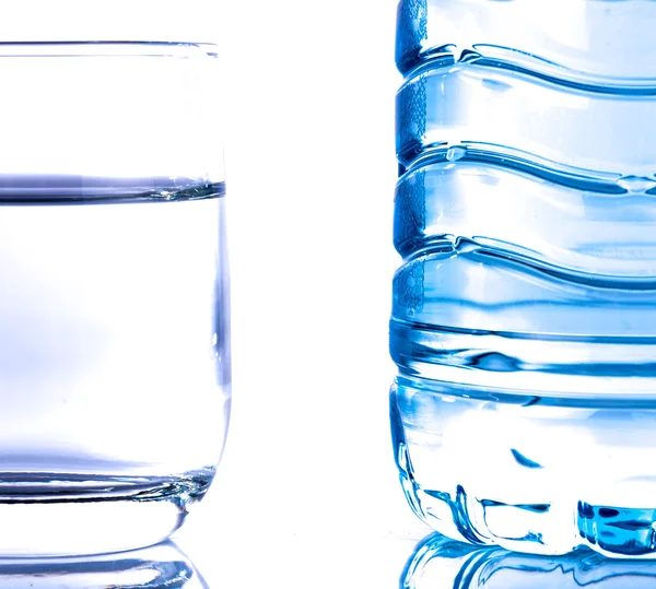 Botella de agua de plástico con un vaso —  Fotos de Stock