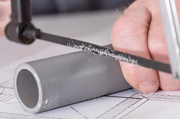 Plumber sawing a pvc pipe — Stock Photo, Image