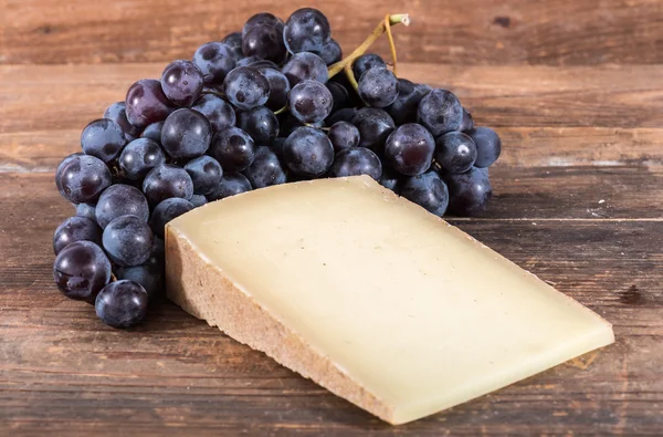 Queso de conte francés con uvas negras — Foto de Stock