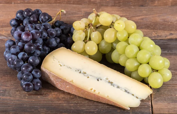 French morbier cheese with black and white grapes — Stock Photo, Image