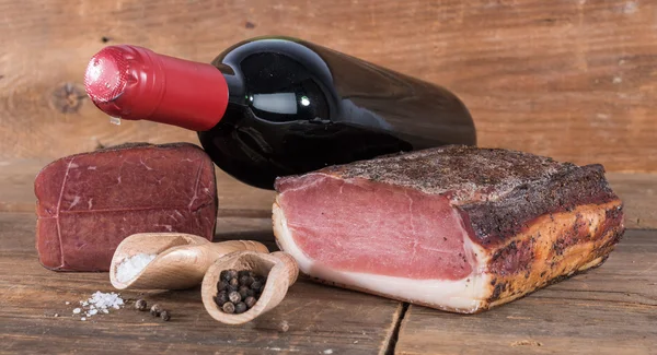 Копчене м'ясо з пляшкою вина — стокове фото