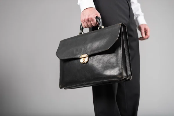 Businessman standing and holding a briefcase — Stock Photo, Image