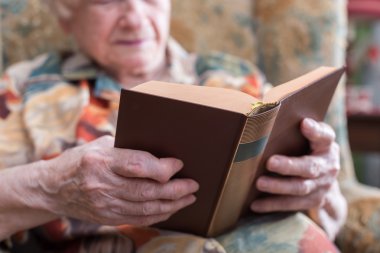 Kitap okuyan yaşlı bir kadın.