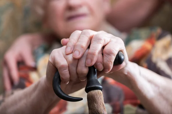 Vieille femme avec ses mains sur une canne — Photo