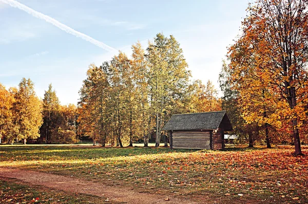 Wooden house in the village - autumn rural colored landscape in sunny weather