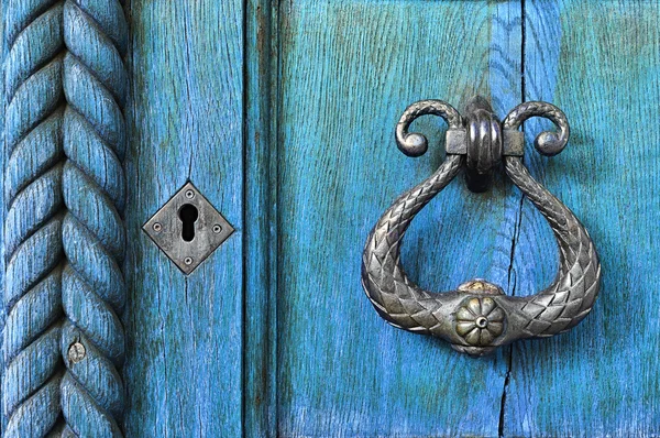 Old wooden light blue door  with old metal door handle