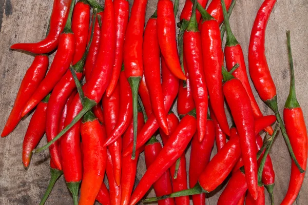 Ahşap arka plan üzerinde kırmızı sıcak chilies — Stok fotoğraf