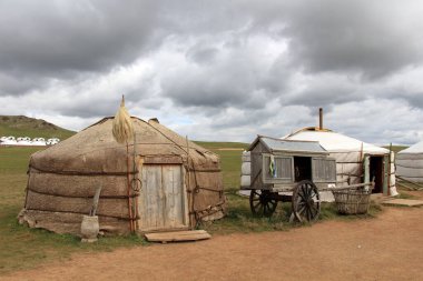 Geleneksel göçebe çadırları ve Moğolistan 'ın başkenti Ulaanbaatar' ın kırsal kesimlerinde tahta tekerlekli bir at arabası..
