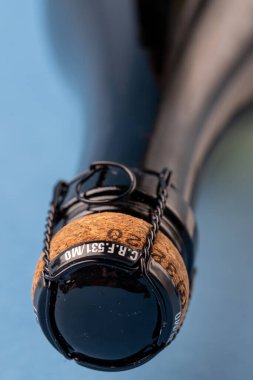 Mavi arka planda bir şişe şampanya. Büyük boy.