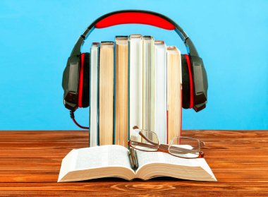 Ses kayıt cihazları, kitap yığınları ve ahşap arka plana karşı kulaklık konsepti.