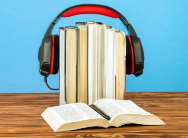 Ses kitapları, kitap yığınları ve mavi arka plandaki kulaklıklar için kavram.