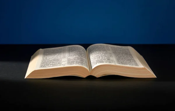 Biblia Abierta Sobre Fondo Oscuro Imagen de stock