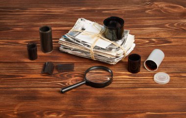 Eski fotoğraflar, büyüteç, ahşap bir masanın üzerindeki negatifler..