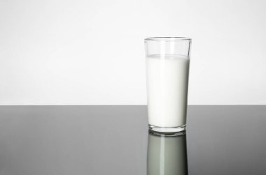 Süt ve mayalanmış süt ürünleri: vücuda yarar sağlar. Masada bir bardak süt..