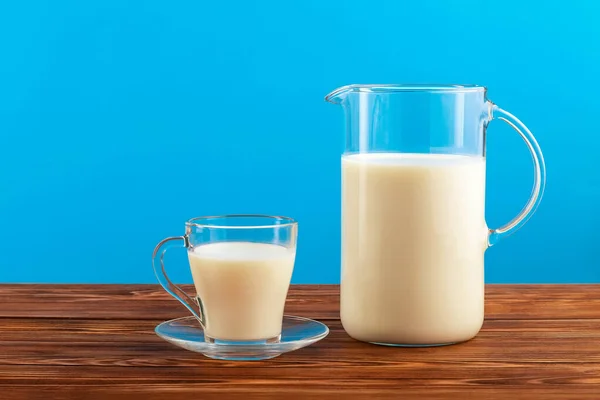 Ein Krug Und Ein Glas Milch Auf Einem Holztisch Vor — Stockfoto
