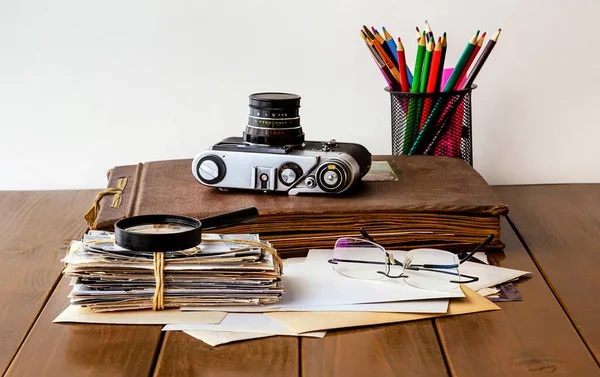 Albums with old family photos on a wooden table.