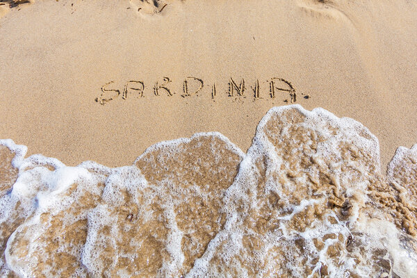 Sardinia word drawn on the beach
