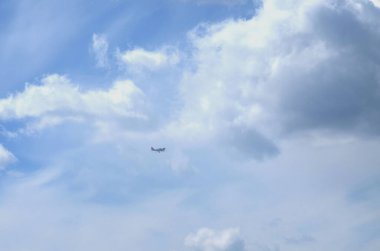 Gökyüzünün arka planında bulutlarla kaplı, uçak uçuyor.