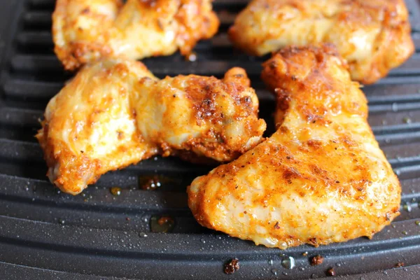 Tasty chicken wings on a portable grill.