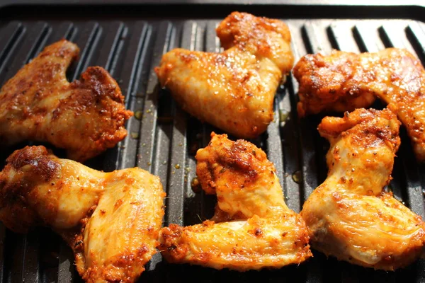 Tasty chicken wings on a portable grill.