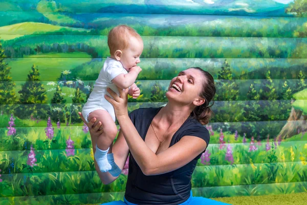 Anne ile bebek jimnastiği yapıyor