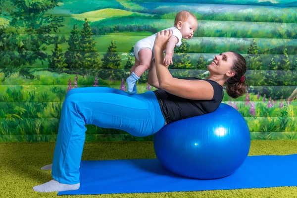 Anne ile bebek jimnastiği yapıyor