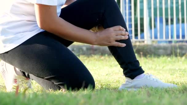 一个年轻女人在草坪上慢跑时扭伤了脚踝 健康的运动理念 — 图库视频影像